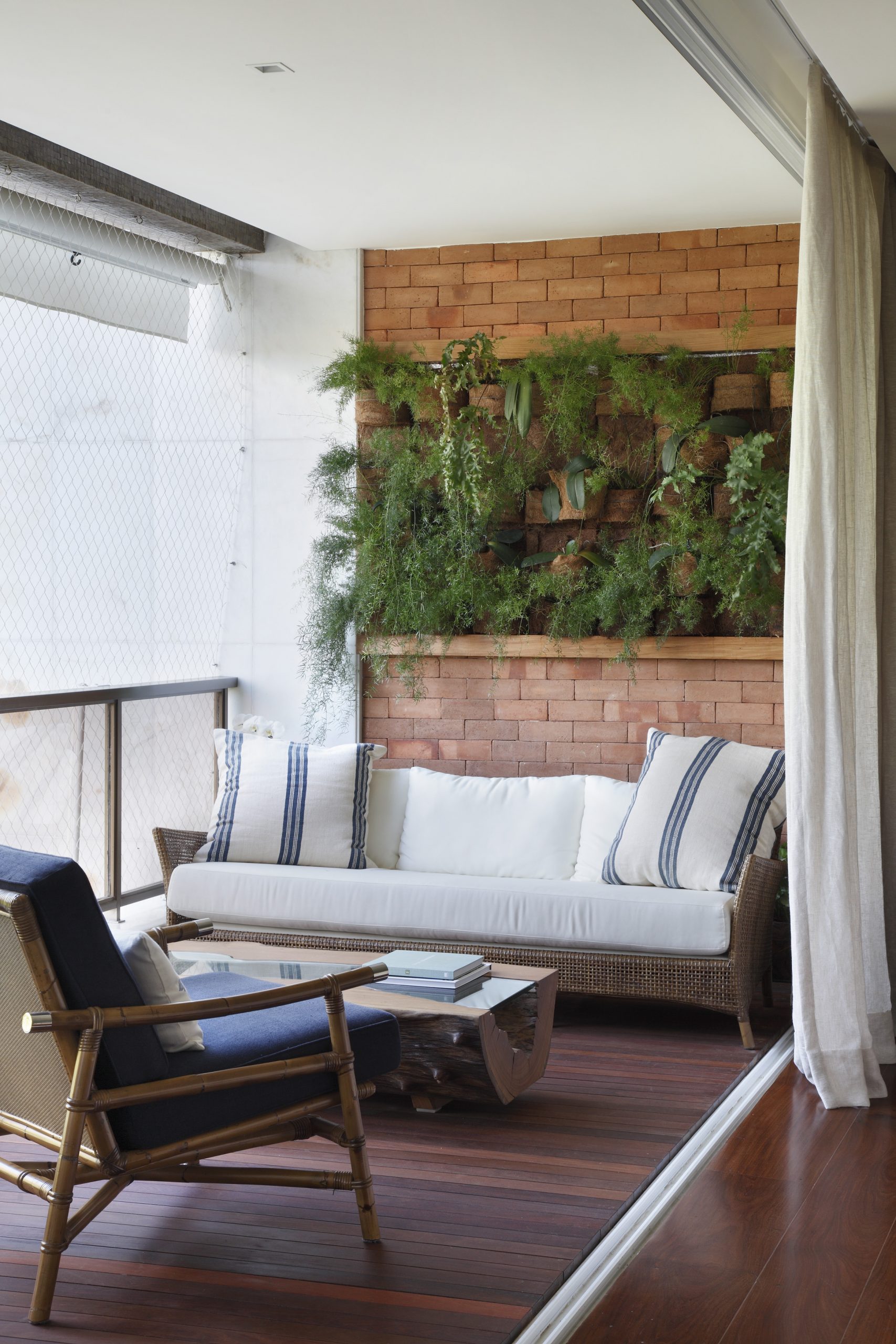 varanda de apartamento com sofá, cadeira e diversas plantas